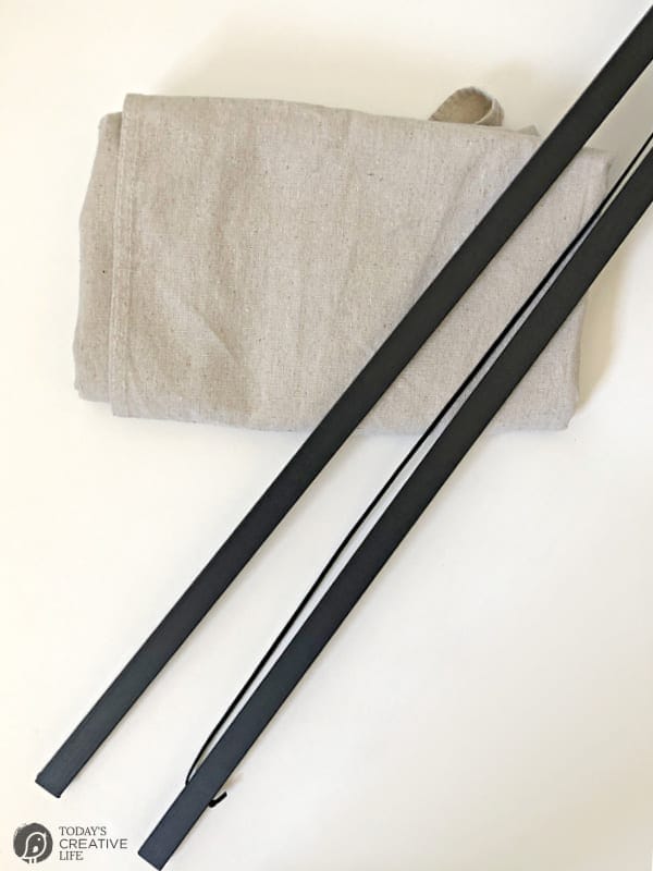 Folded canvas drop cloth with magnetic wall hanger